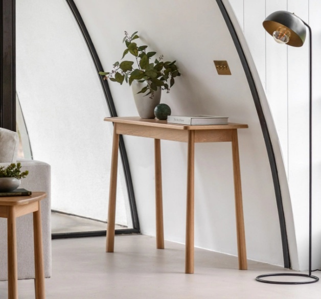 The Gallery Direct Wycombe Console Table styled against a white wall with décor, emphasising its natural oak Nordic aesthetic