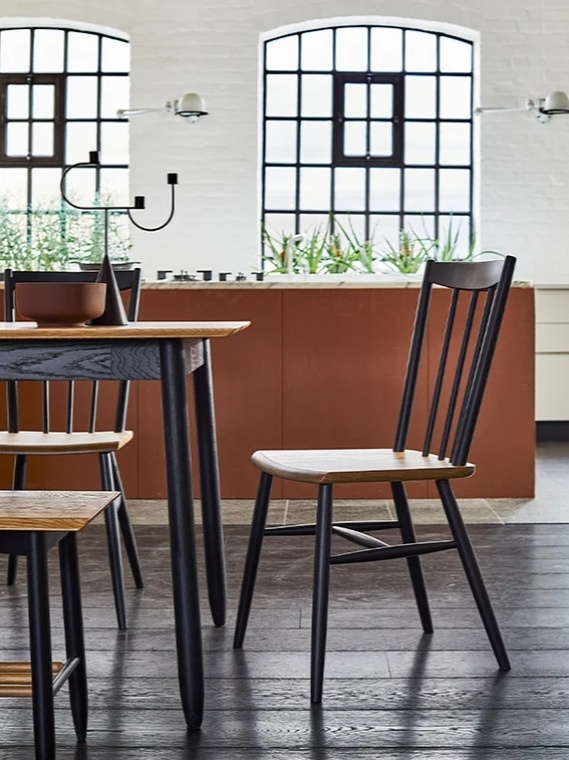 Industrial style kitchen dining area featuring Ercol Monza black spindle chairs and matching oak dining table against a white