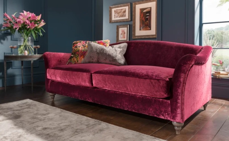 Spink & Edgar Lamour Midi sofa by Tetrad in rich red velvet with curved arms in a stylish living room setting