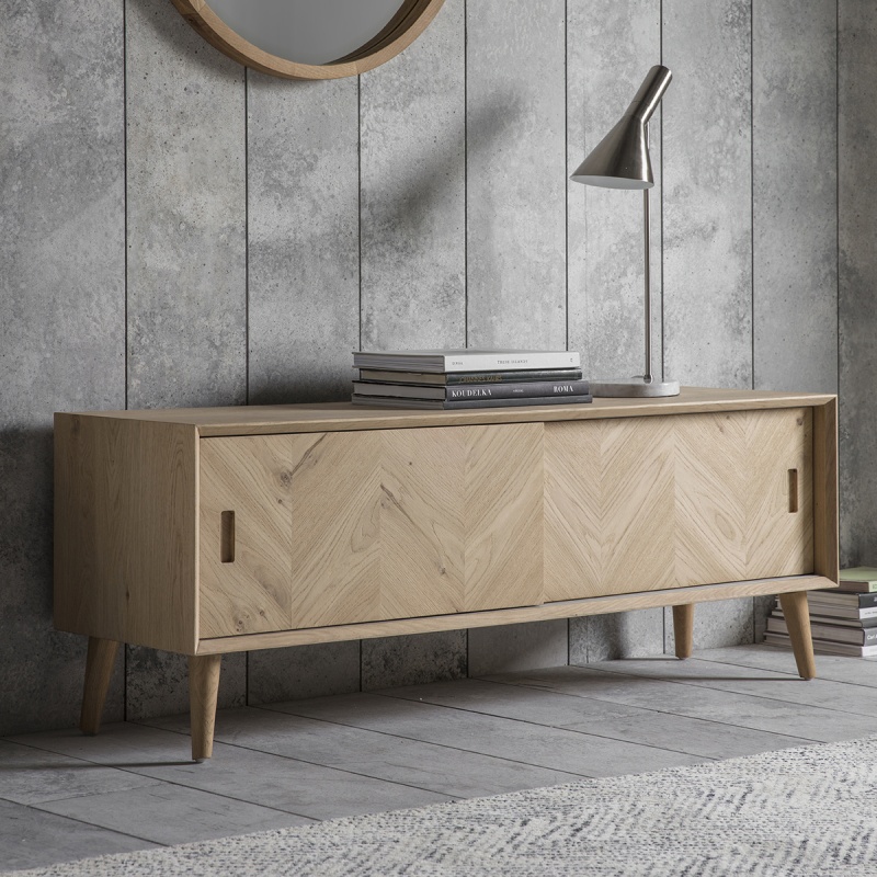 Gallery Milano Media Unit in European oak with chevron sliding doors, styled in modern living space with soft lighting
