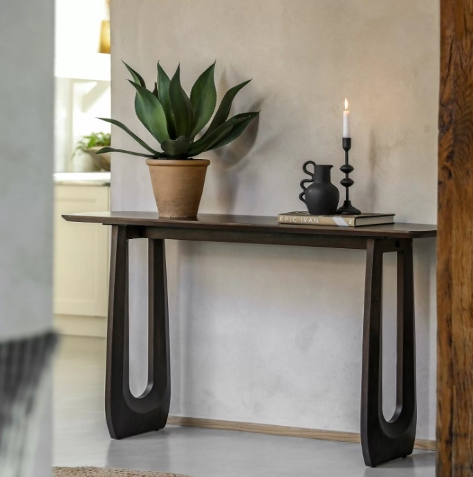 Styled hallway scene featuring the Gallery Arc Console Table in dark mango wood with bold carved U-shaped legs