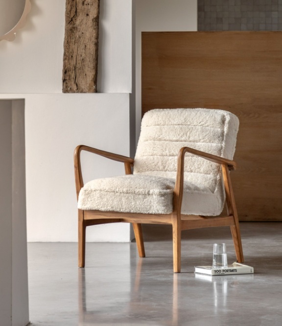 Gallery Direct Datsun Chair Cream Sheepskin on marble floor with a book and glass on top next to it