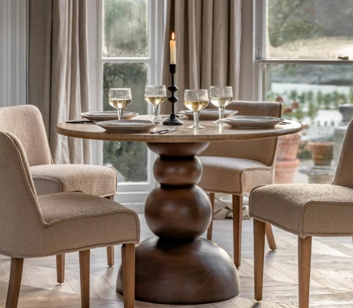 Dining space styled with the Gallery Sculpt Round Dining Table featuring a travertine top and bold stacked mango wood base