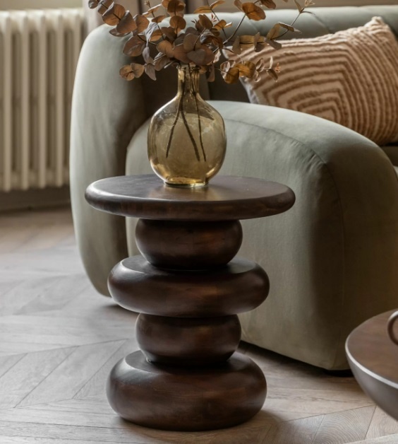 The Gallery Sculpt Round Side Table styled beside a sofa with deep mango wood finish and bold sculptural retro design
