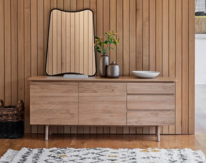 Gallery Direct Madrid 2 Door 3 Drawer Sideboard Oak against a wood panelled wall