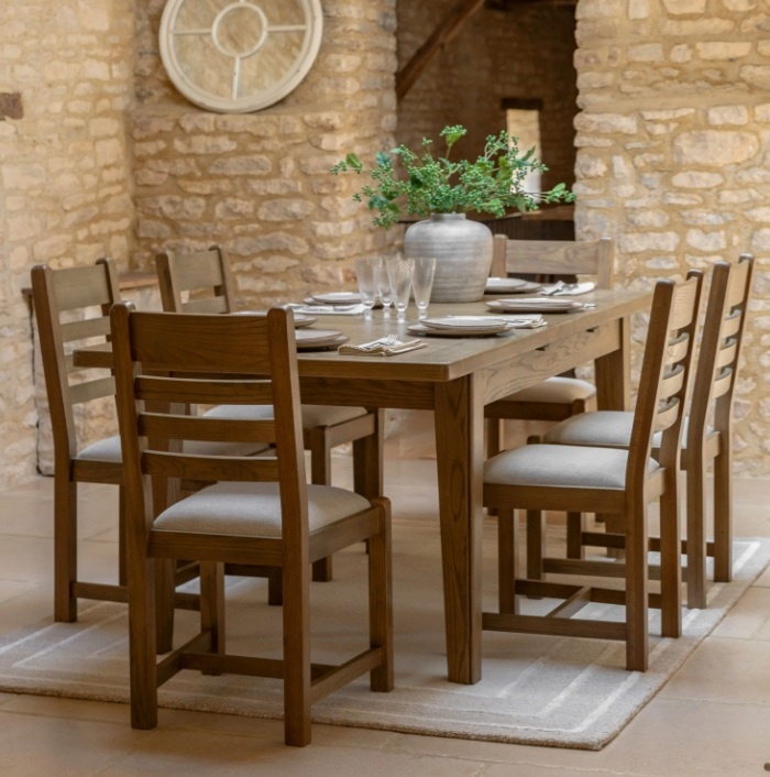 Gallery Direct Hardwick Extending Dining Table and chairs stone walled room with cream rug and table laid