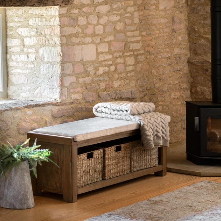 Gallery Direct Hardwick Hall Bench in cottage lounge by stone window next to wood burner with a jumper on top