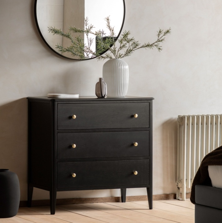 Gallery Direct Acton 3 Drawer Chest Black with white vase on top and round mirror on wall