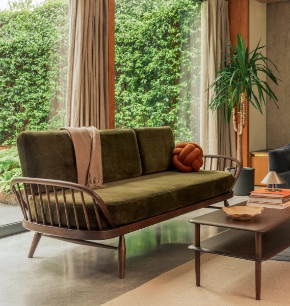 Ercol 7355 Studio Couch in Dark Wood Finish with Green Velvet Upholstery in a modern living room setting - Brentham Furniture