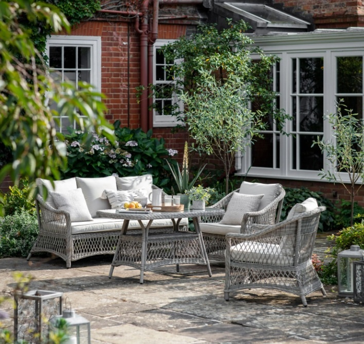 Gallery Menton Stone rattan 4 piece garden sofa dining set on outdoor patio with cushions