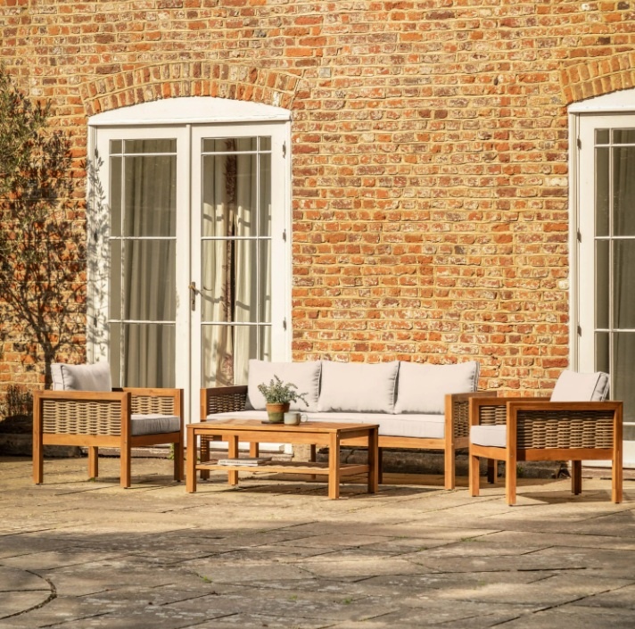 A luxurious Belize garden sofa set styled on a sunlit patio against a classic brick wall for a modern outdoor living aestheti