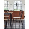 Industrial style kitchen dining area featuring Ercol Monza black spindle chairs and matching oak dining table against a white