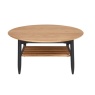 Ercol 4069 Monza Round Coffee Table in Patina Oak featuring a circular top and black spindle storage shelf - Brentham Furnitu