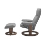 Side view of Stressless Consul ergonomic chair and footstool showing the classic oak wood base in grey leather