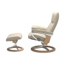 Side view of Stressless Consul chair and stool showing the signature aluminum and wood rocking base in cream leather