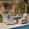 Gallery Garden Holton 7-seater rattan rectangle dining set in stone with plush grey cushions on a patio by a pool.