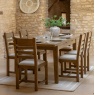 Gallery Direct Hardwick Extending Dining Table and chairs stone walled room with cream rug and table laid