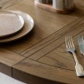 Gallery Direct Hardwick Round Extending Dining Table with cutlery on top and plates