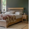 Gallery Direct Malvern Double Bed in bedroom on rug next to bedside chest with lamp with grey painted walls and white victori