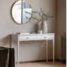 Gallery Direct Acton 2 Drawer Console White with brass round mirror on wall above