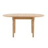 Eton round extending dining table shown closed in a natural wood finish