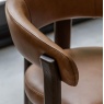 Close up of Gallery Direct Onda dining chair brown leather armrest and wood frame